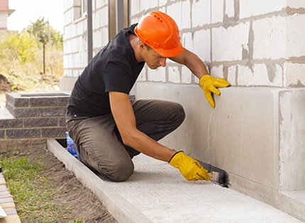man repairing a concrete on a home foundation