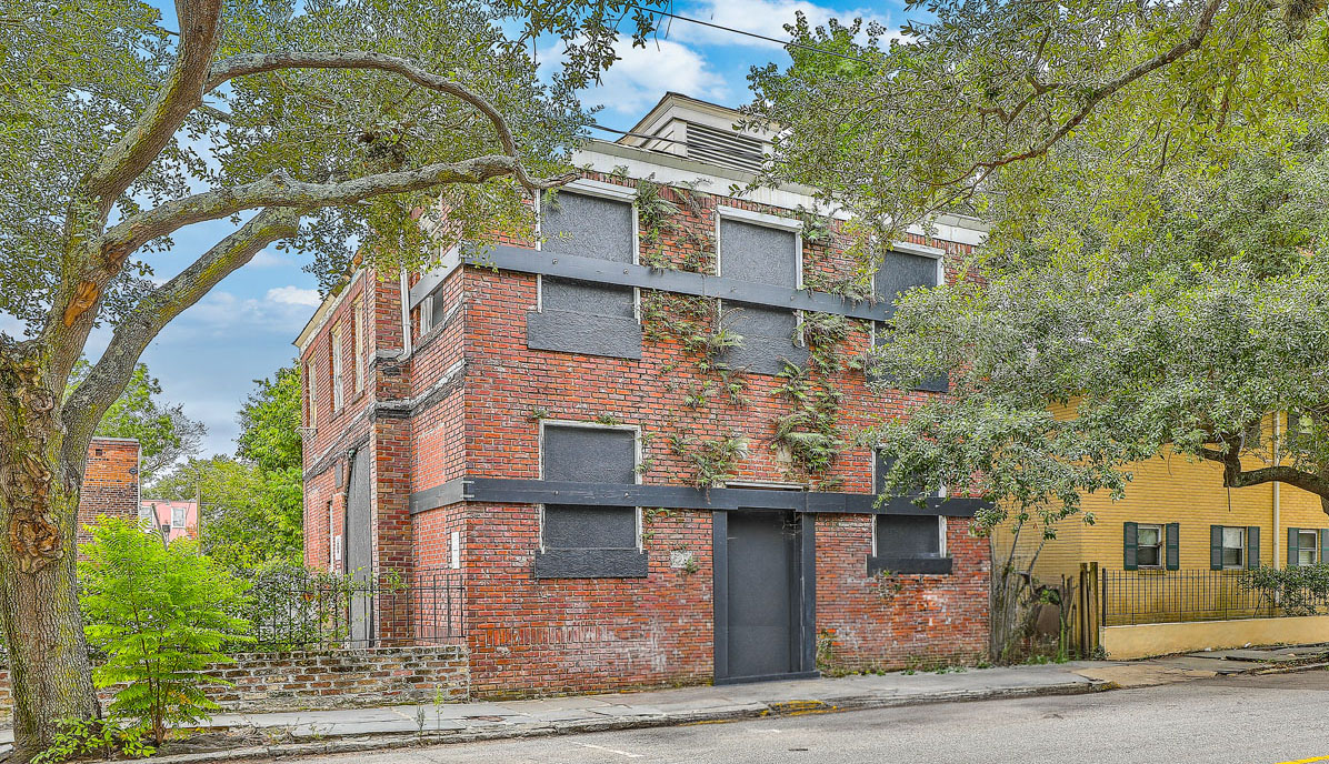 115 Wentworth Street exterior. Two-story vacant brick office building with boarded up windows.