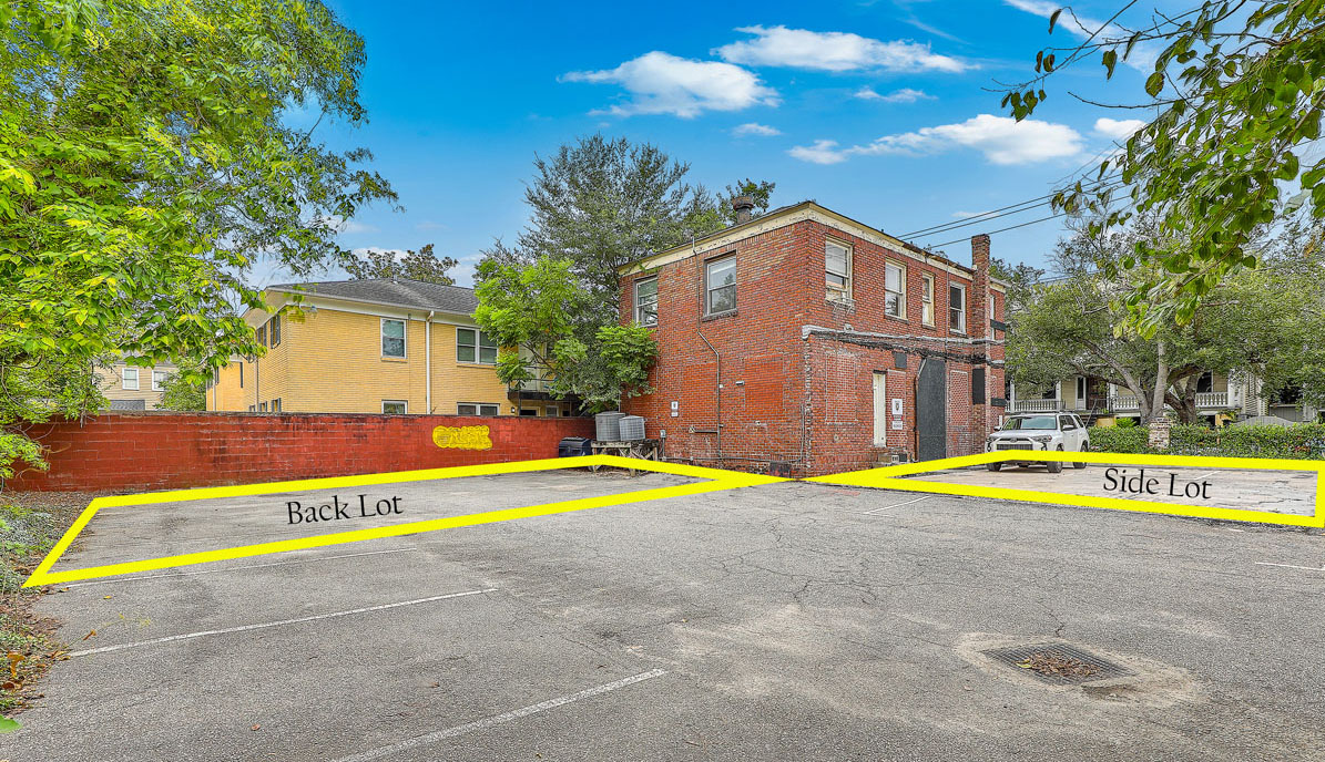 115 Wentworth Street lot lines. Vacant brick office building with boarded up windows from the back with parking lots surrounding it.