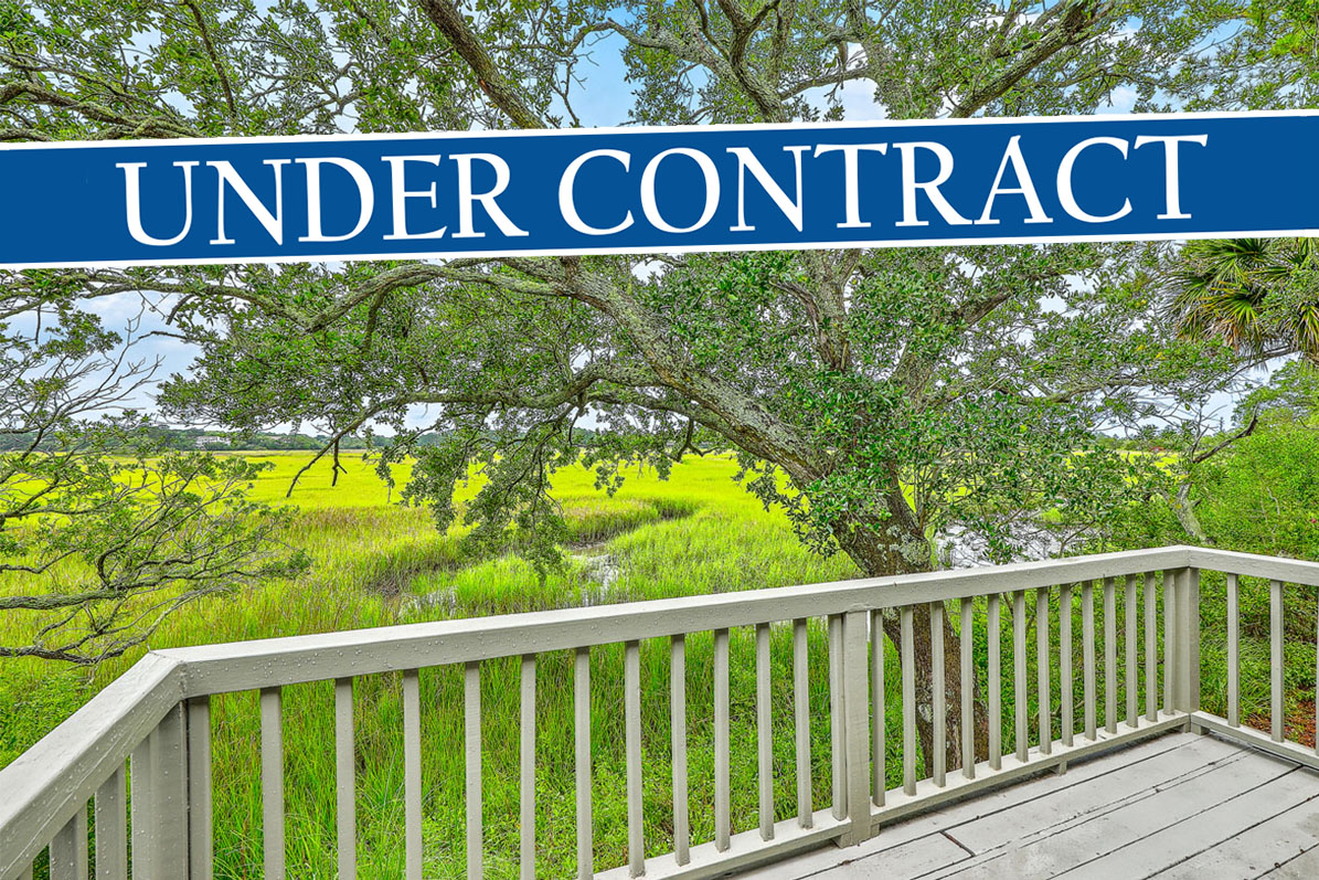 Marshfront view of Ellis Creek with large oak tree from the deck of the waterfront condo for sale at 638 Harbor Creek Place on James Island, Charleston, SC with banner reading "Under Contract"
