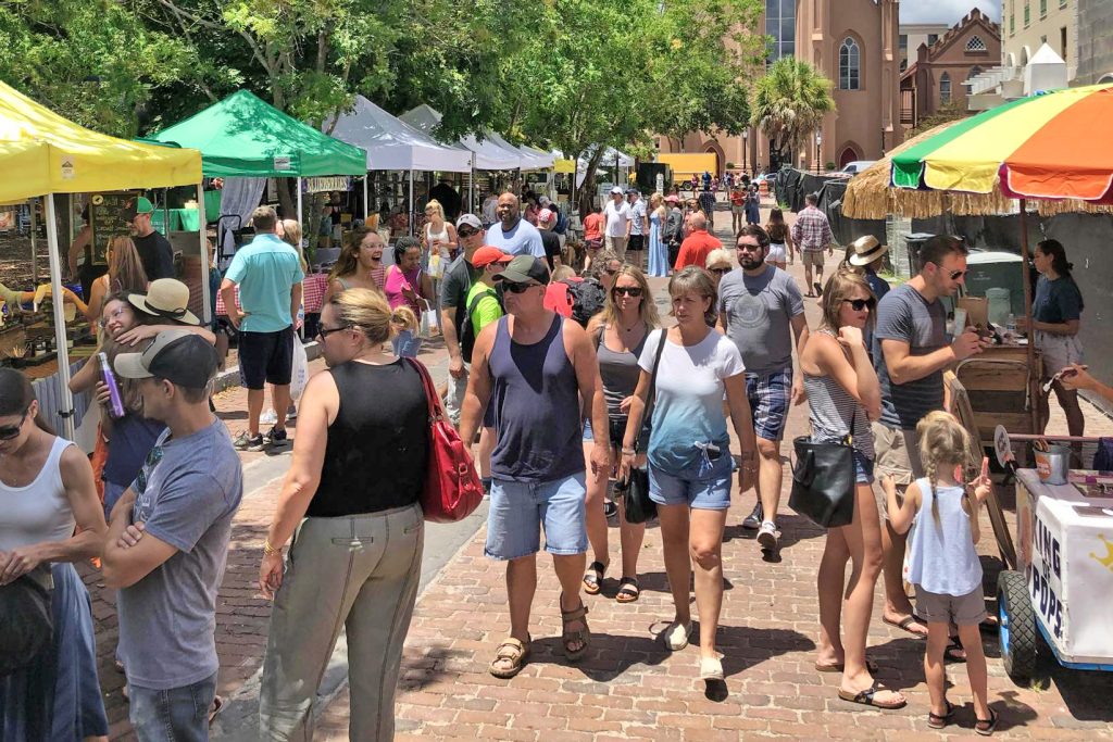 Diverse people walk through a farmers market in Charleston, SC